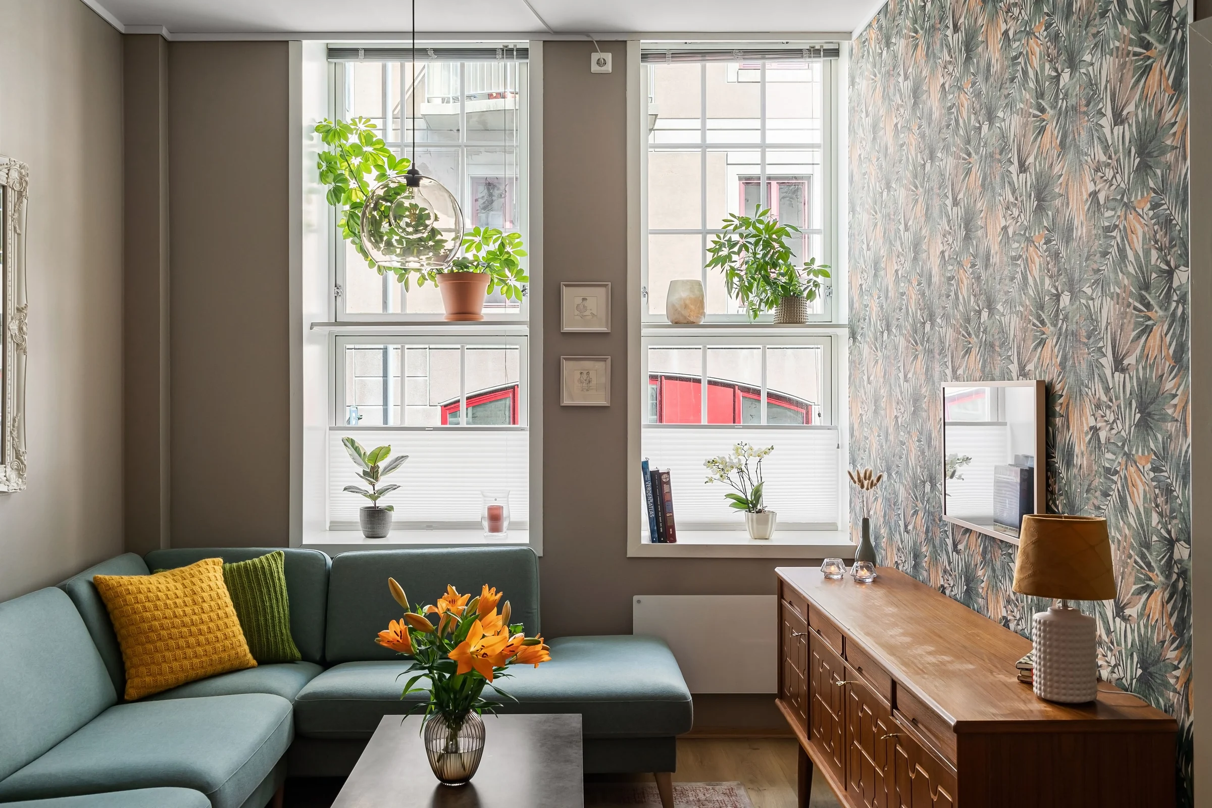Bright sitting room with leafy wallpaper on a feature wall